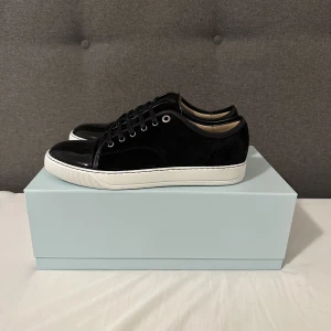 Lanvin skor - Svarta Lanvin skor, storlek UK 8 (passar 42-43). Helt nya, enbart upptagna för att ta bild. Allting medföljer och kvitto finns. Nypris: 4299 kr, mitt pris: 3400 kr. Kontakta mig vid frågor eller funderingar!