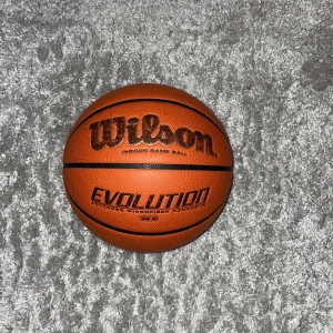 Basketboll  - Wilson evolution basketboll. Använd i 5 månader då det därför som man kan se att bollen tappat lite färg på texten men allt annat funkar helt perfekt och exakt som ny, inga slitningar eller problem! Storlek 6 och säljer för den ej används!