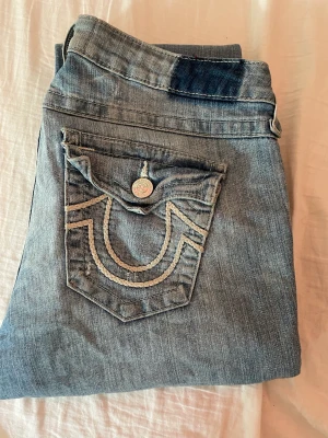 Lågmidjade True Religion Jeans - Säljer nu mina True Religion Jeans för de inte kommer till användning, de är i bra kvalitet och inga defekter 😁 lappen som sitter där back är dock inte kvar. De är köpta på Seams Vintage för 1000 kr. Ge gärna prisförslag och kontakta för frågor mm.