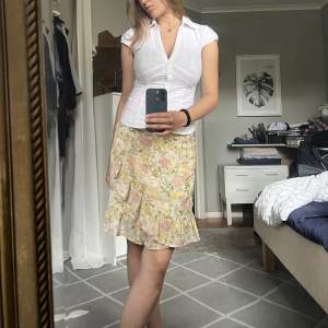 Supergullig kjol med volang och blommor. Den är knappt använd och i väldigt bra skick. 