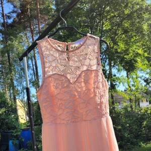 Rosa klänning med virkad detalj - Säljer en rosa klänning med hjärtformad urringning. Är knappt använd. 