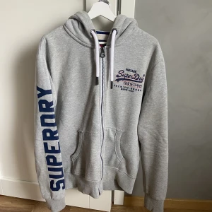 Hoodie från Superdry  - Hoodie från Superdry i storlek Large för herr. Fin färg och passform. Använd men i mycket gott skick. 