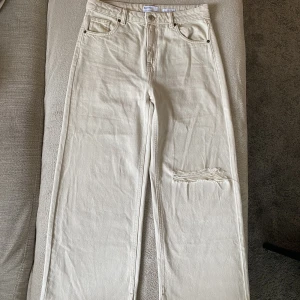 BERSHKA BEIGE JEANS - Beiga jeans från Bershka i nytt och bra skick, helt oanvända. Storlek 38, högmidjad, säljer pga för tighta vid låren. Men annars väldigt fina och snygga jeans.