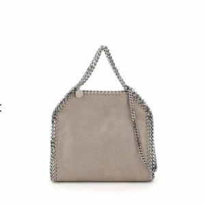Stella McCartney falabella väska  - Jag säljer nu min Stella McCartney väska i storleken ”Mini Tote”. Väskan är köpt sommaren 2020 på Farfetch. Äkthetsbevis medföljer!  Tecken på användning finns vilket är svårt att undvika med tanke på färgen, skriv för fler bilder!💕  Nypris: Ca 10 000 kr 