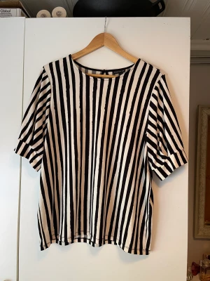 Blus - Vit-svart randig blus. Storlek: L. 