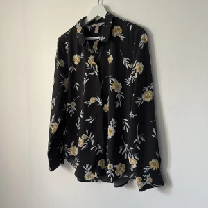 Blommig skjorta - Helt ny och oanvänd skjorta från H&M i svalt material.   Rensar ur min garderob från en hel del oanvända kläder🌼 Kika och se om du ser något mer i min profil som du gillar så skickar jag med det till dig också!😊 Fler kläder kommer!  