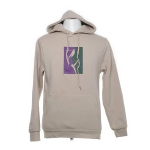 Hoodie med motiv - Snygg och skön beige hoodie med lila/grönt motiv på framsidan!🍂🕷️🦎Nopprig men annars väl omhändertagen! Storlek S i ”herrstorlekar”