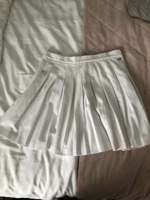 Vit vecklad kjol  - Pull & Bear Pacfic republic kjol. Material: 62% polyester 33% Viscos 5% elasthanne Skick: Aldrig använt pga att den är för liten  Fördel: Underkläder syns inte egenom, inga fläckar, skön känsla Nackdel: liten storlek (passar litet M och S)