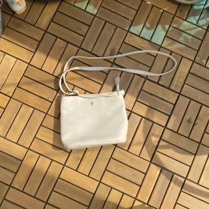 Väska  - En beige axelremsväska som är köpt på glitter för längesedan men har inga defekter. 