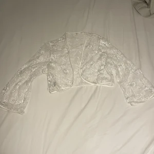 Kort spets-throwover - Superfin throwover med utsvängda ärmar. Finns så snygga sätt att styla den på🙏 Ganska stor i storlek men väldigt snygg att slänga över nåt som sitter lite tightare :) Kan mötas i sthlm alternativt frakta!