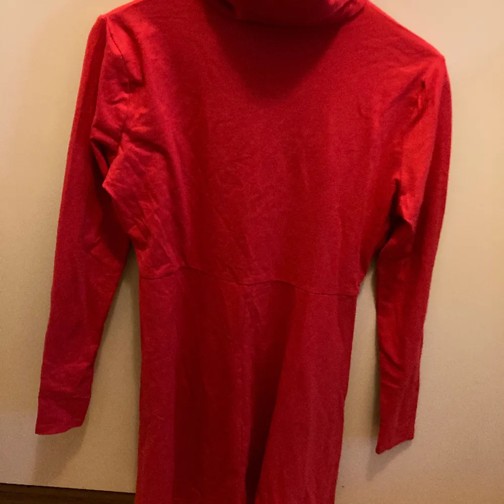 En helt oanvänd röd klänning från märket Boohoo. Vanligt rött tyg och är i storlek M/40. Har en hög halskrage. . Klänningar.