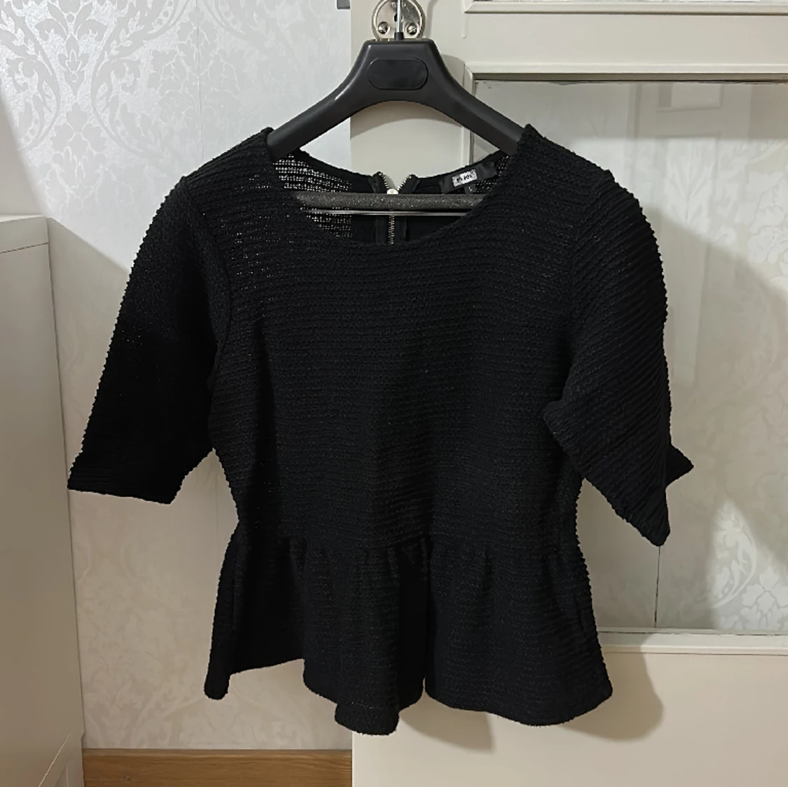 Svart tröja med volang ner till 