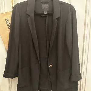Tunn svart kavaj - Tunn svart kavaj från New Look, köpt i London. Storlek 38. Är en ”mjuk” kavaj pga tunnare tyg. 