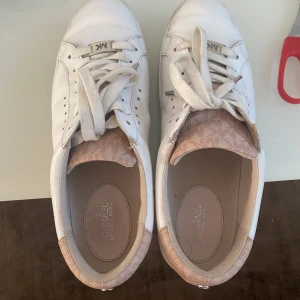 Fina Michael Kors skor - Säljer mina Michael Kors skor då de blivit för små för mig och inte kommer till stor användning. Jättefina basic sneakers köpta 2021 för 1500kr säljs för 350kr. Skorna är i ganska bra skick och har inga större defekter.