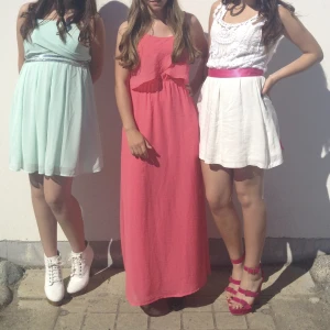 Långklänning  - Korallfärgad långklänning i chiffongliknande material. Hittar ej storlek med skulle säga S. Uppsydd för att passa mig, är 160 cm och har haft klackar när jag använt den. Använd 2 ggr. 