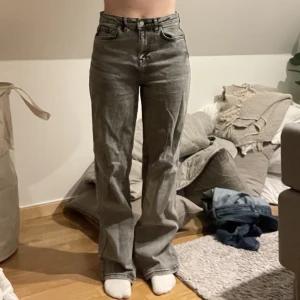 Jeans - Ett par högmidjade jeans från madlady med vidaben . De är smutsgråa i färgen och är i storleken 36-short vilket passar mig som är 163cm lång. De är i mycket bra skick och har inga defekter.
