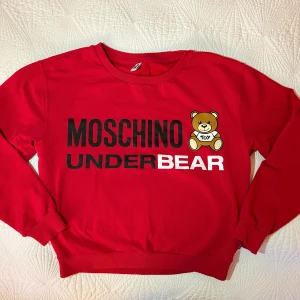 Moschino Hoodie Dam strl S - Nyskick. Använd 2-3 gånger. Storlek S i bomull.  Nypris: 2.200:- Säljer den för att jag inte använder den alls och den bara hänger i garderoben.   Inga skador eller slitage alls. 