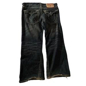 Trueys  - Tvärfeta trueys! Knapparna på bakfickorna är utbytta och det är lite slitningar längst ner på benen (se bild 1). Annars är det inga andra hål eller liknande!