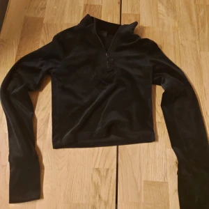 Svart kort tröja - Croppad långärmad tröja/magtröja. Fint skick, lite skav på kedjan, se bild. Hund finns i hemmet.
