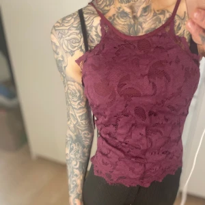 H&M - Vinröd/mörklila topp, spetstopp, strl 34 - Spetstopp från h&m i storlek 34. Har blivit ljusa trådar på sidorna och i bak. 