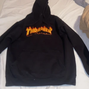 Trasher hoodie - Svart hoodie med eld text, lite använd, skick 8/10, XL