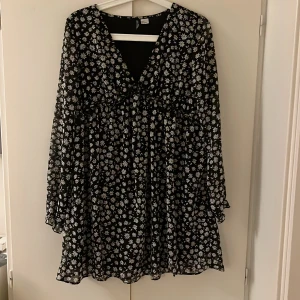 Blommig klänning  - Svart miniklänning med vita blommor på, bra skick 