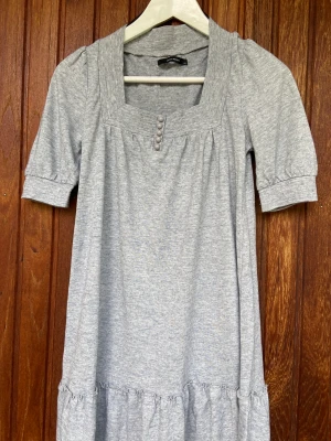 Klänning från Vero Moda - Kort klänning från VERO MODA med fyrkantig urringning och fina detaljer.