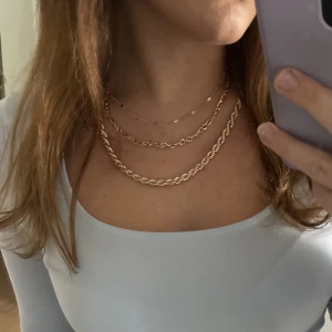 Halsband - Ett halsband med 3 kedjor i. Ej äkta guld men håller färg och ger inga märken. 