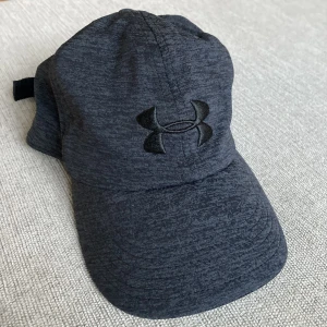 Under Armour Keps - Säljer en Under Armour Keps! Den är mjuk och har inga hårda kanter så är perfekt om man tränar eller bara vill ha en bekväm keps! Storlek OneSize. Kan gå ner i pris vid en snabb affär, tveka inte på att skriva om du har några funderingar!