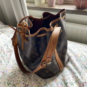 Louis Vuitton väska vintage - Säljer denna vintage LV väskan i modellen petit noe 🌸✨ Köpt från the vintage bar. Vattenfläckar i botten, därav priset. Äkthetsbevis finns. PM för fler bilder eller frågor!