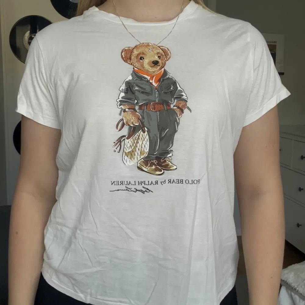 Vit Ralph lauren t-shirt med den klassiska björnen på. Säljer pga använder inte lika mycket som tänkt.  Storleken är en Large i barn men passar som en Small.  Är dom ny! 🤍. T-shirts.