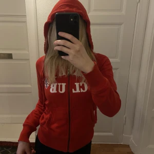 Röd hoodie  - Röd somrig hoodie!! Snyggt åtsittande med en vit text där det står ”berkeley.” Den är mjuk och har bra kvalitet 