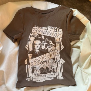 Brun t-shirt - En fin brun t-Shirley med ett fint tryck på. Storlek S men sitter som S skulle jag säga. Aldrig använd och i jättefint skick. Köpt på SHEIN.