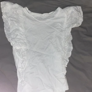 Vit t-shirt med spets på sidorna - Det är en oanvänd t-shirt som helt enkelt var för stor för mig.