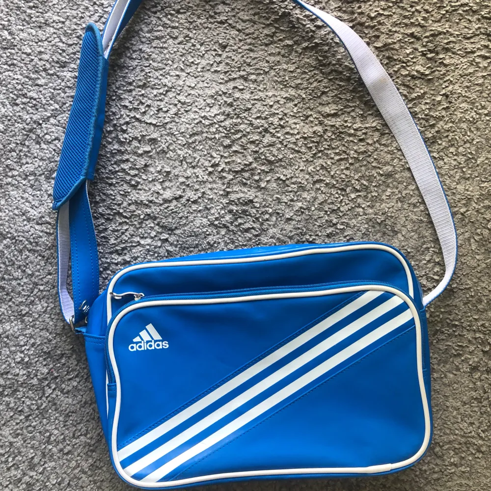 En fin blå axelväska från Adidas i bra skick. Den ser ny ut men har lite skrapning på kanterna men ingen som märks. Köp gärna genom köp nu🫶🏼. Väskor.