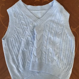 Stickad väst - En blå stickad väst som passar bra till både sommaren och vintern! Har tyvärr ingen lapp så vet ej vart den kommer ifrån.
