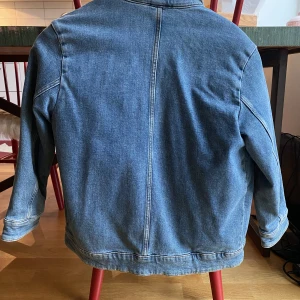 Fodrad jeansjacka barn - Oanvänd fluff-fodrad jeansjacka från ARKET i storlek 134  Fodret är avtagbart.  Nypris ca 900 kr.