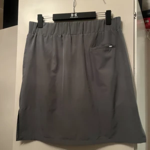 Golfkjol - En längre golfkjol med fickor med shorts i. 