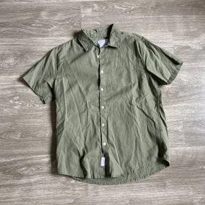 Skjorta - Kort armar skjorta. Storlek M från lager 157. Mått: Längd 67-70cm. Armhåla till armhåla ca 56cm.