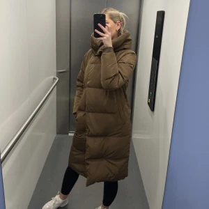 Brun lång dunjacka - Köpte förra säsongen, i fint skick. Med huva.