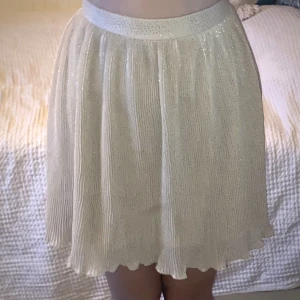 Gullig rosa/beige glittrig kjol - Kjol från H&M i strl 34. Bra skick, inga defekter. Silvriga glitterprickar ish.