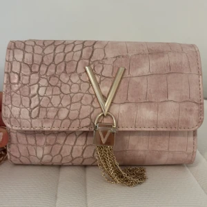 Valentino väska - Säljer min helt oanvända red valentino väska. Den har aldrig använts så den är helt ny, nypriset är ca 900kr. Plasten är fortfarande kvar på låset🩷