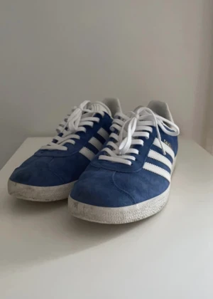 Adidas Gazelle 41⅓ (US8M) - Blå vita adidas Gazelle i storlek 41 ⅓ (US8M)  Jag har använt dom typ 5-10 gånger. Fick dom i present, så har inte kvar kvitto 