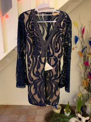 Finklänning  - En mörkblå samt genomskinlig kort finklänning som är oanvänd. Har även kvar lappen på sig.  Kontakta mig innan ni trycker på ” köp nu”, tack! Vid frågor, skriv! 