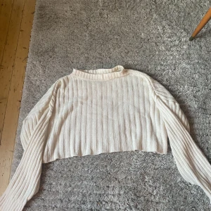 Vit tjocktröja  - Vit tjocktröja med långa armar. I storlek M, med lite kortare passform runt midjan. Den har som ett plisserat mönster över hela tröjan. 