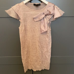 Tröja med rosett - Jätte gullig topp med en rosett på, jätte bekvämt typ men tyvärr ett litet hål på nedre delen av framsidan, därav priset