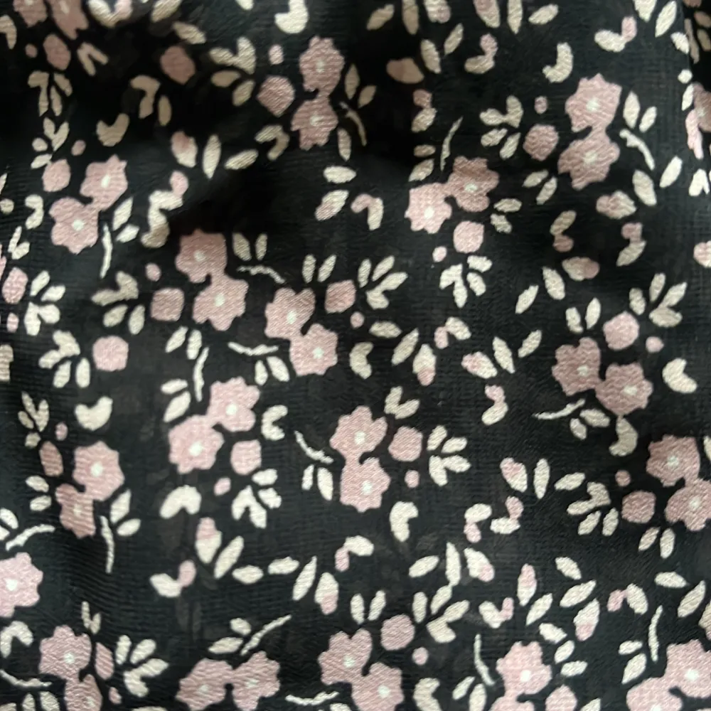En kort blommig volangkjol. 100% polyester. Svart kjol med små lila blommor på. Från Kappahl i stl 146-152. Använd ett fåtal gånger. Kjolar.