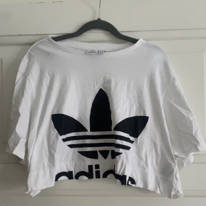 Adidas crop top - En vit croptop med den klassiska adidasloggan i storlek L