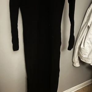 Lång svart klänning  - Säljer en lång tajt ribbad klänning med slits längst ned på båda sidorna. Använd endast en gång. Den är liten i storleken. Köparen står för frakten