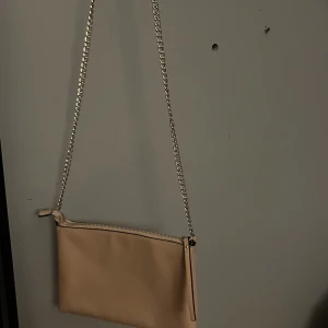 Axelväska - Beige väska med gulddetaljer från hm, super fin men kommer inte till användning längre. Köparen står för frakten